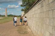 Gruppe und Führer an der Außenmauer der Gedenkstätte Sachsenhausen