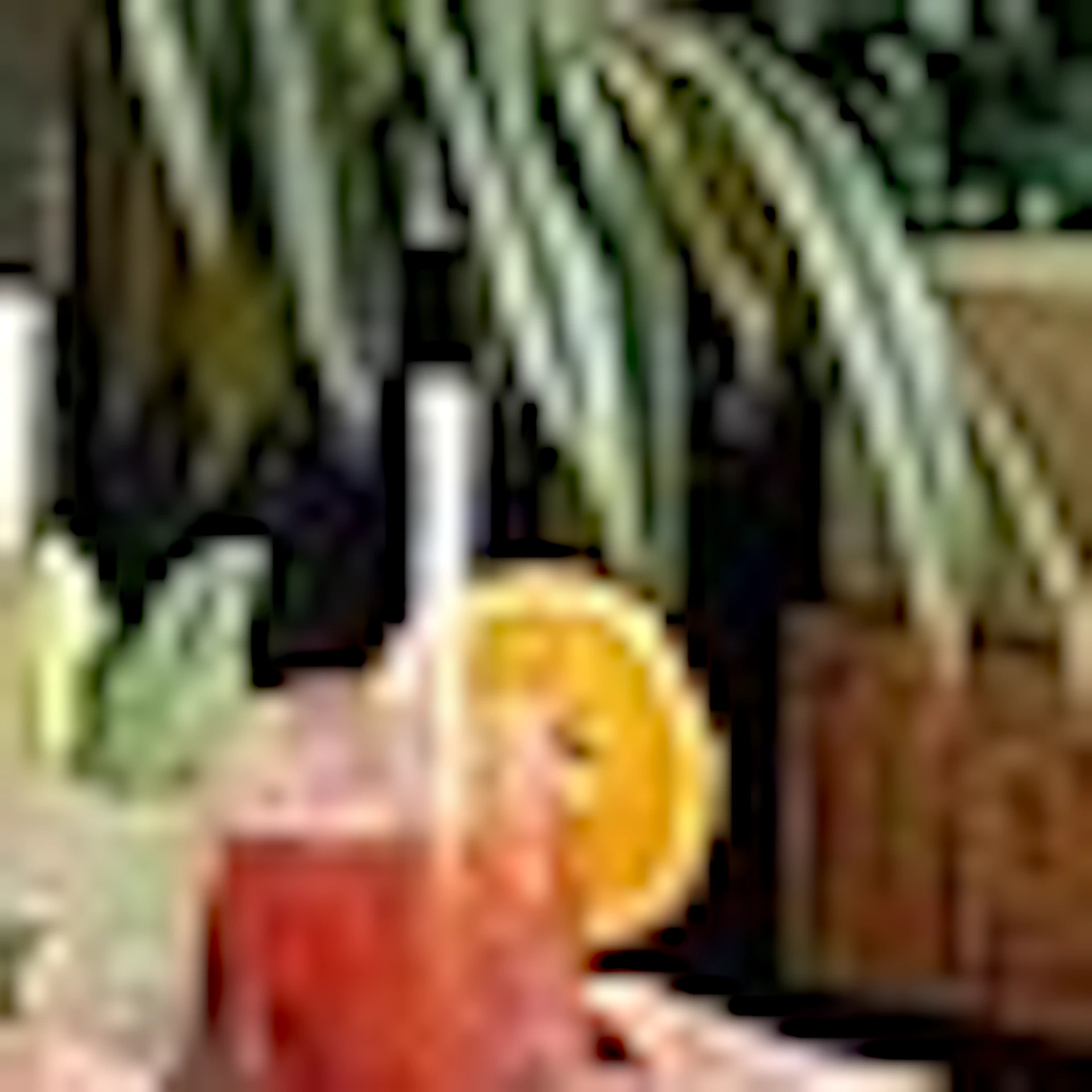 Two people in white robes toast drinks in a lush indoor garden with colorful seating and large plants.