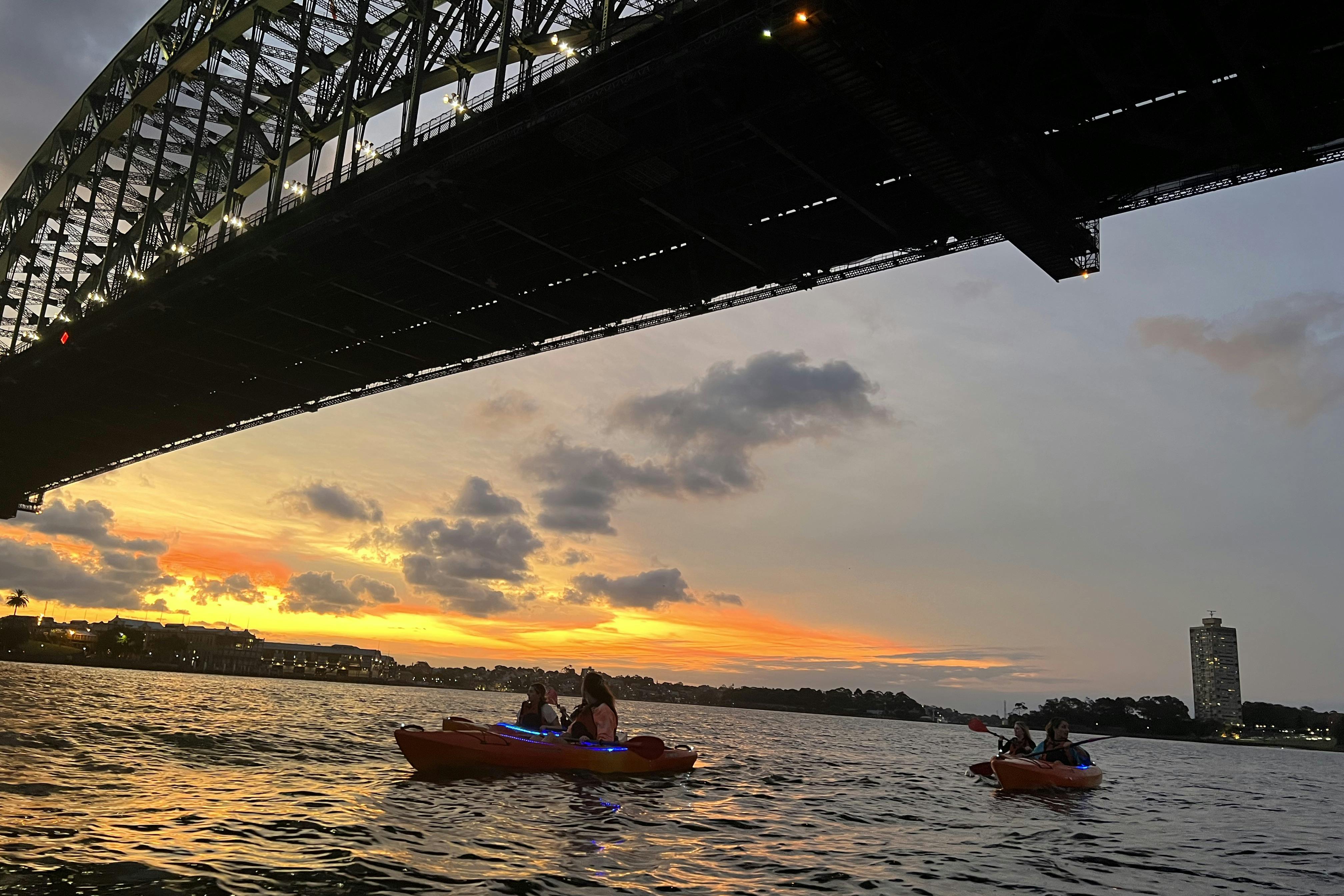 καγιάκ κάτω από τη γέφυρα του λιμανιού του Σίδνεϊ στο ηλιοβασίλεμα