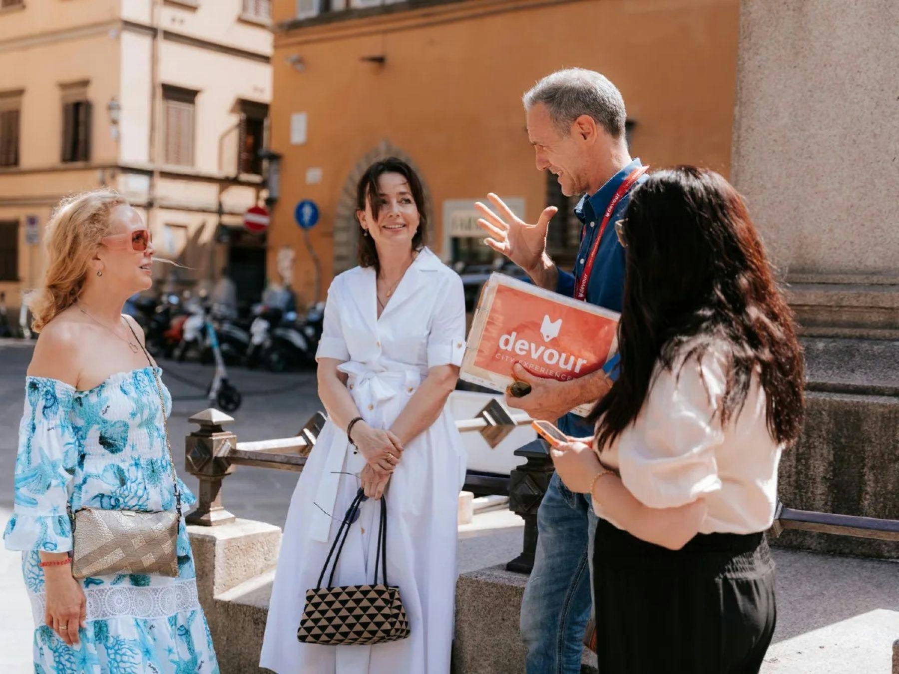 Un gruppo di quattro persone in piedi all'aperto, con una di loro che tiene in mano una cartellina con la scritta 
