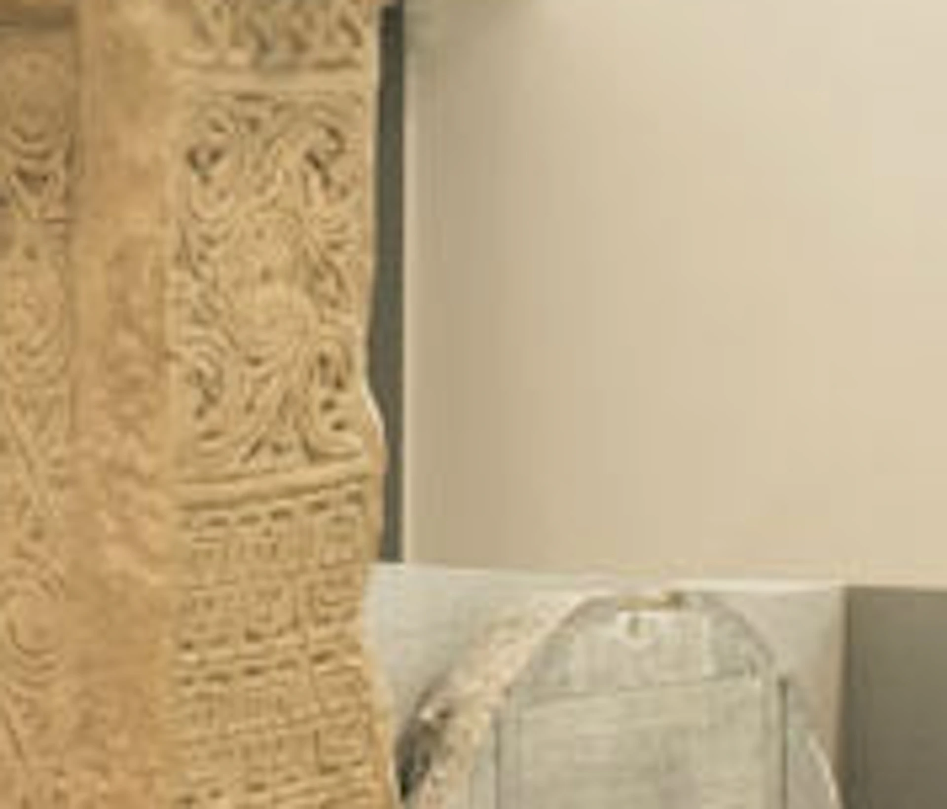 Two large stone Celtic crosses in a museum, with a woman and two children looking at them and another person in the background.