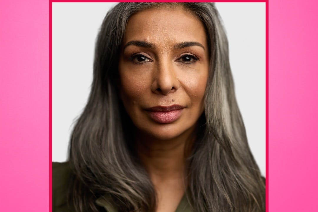 Πορτρέτο ατόμου με μακριά γκρίζα μαλλιά που φορά ουδέτερη έκφραση σε ανοιχτό γκρι φόντο, πλαισιωμένο με κόκκινο.