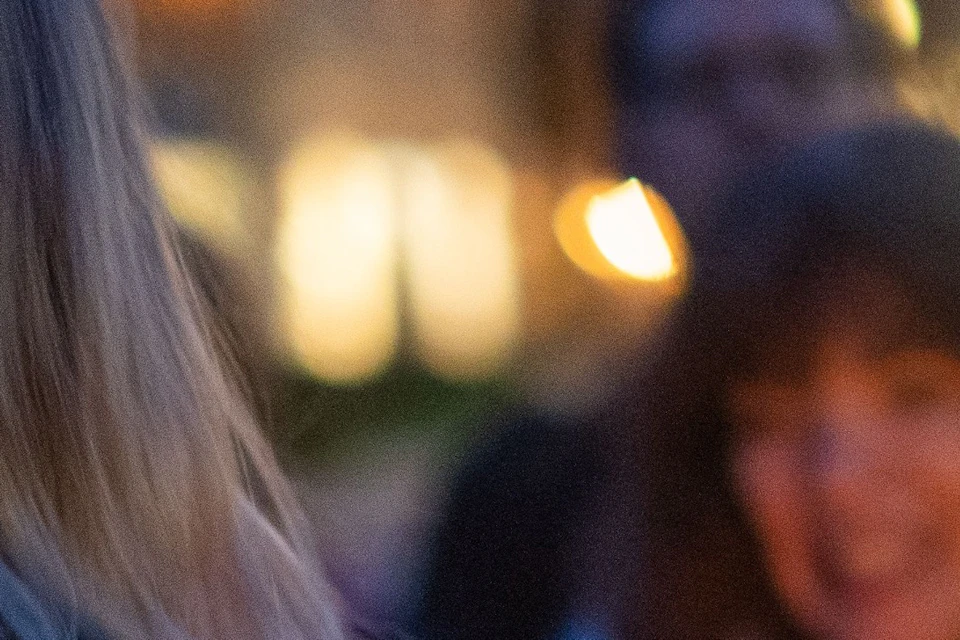 A tour guide holding a lantern while guests gather around to hear ghost stories