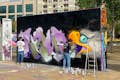 Ο καλλιτέχνης του δρόμου στη διαδικασία δημιουργίας του έργου του σε ένα τείχος της πόλης.