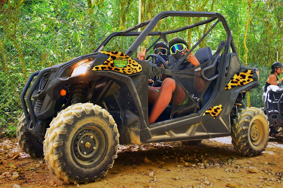 A couple riding in a RZR buggy