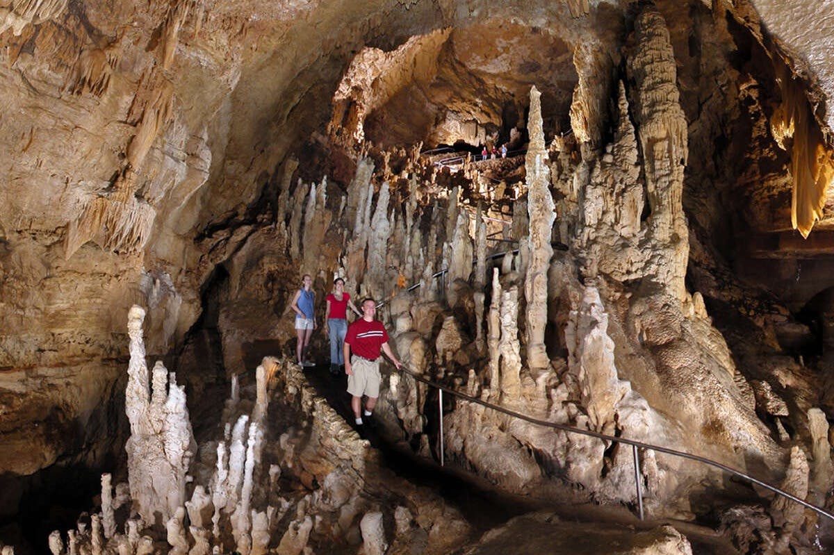 人们沿着洞穴内的小径行走，那里有许多钟乳石和石笋。