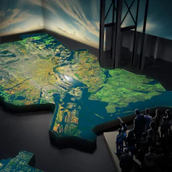 En grupp människor som observerar en stor, upplyst 3D-karta i ett mörkt utställningsutrymme med illustrerad himmel och en flock fåglar.