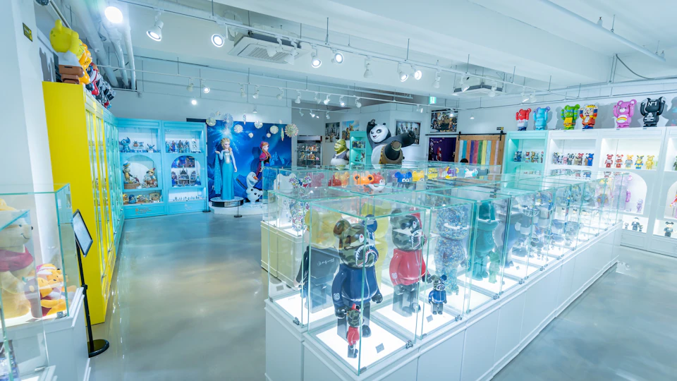 A brightly lit toy store with display cases showcasing figurines and themed decor, including a Frozen character display.