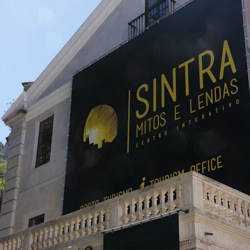 En byggnad med en stor skylt "Sintra Mitos e Lendas Centro Interativo" och "Tourism Office" skriven på portugisiska och engelska.