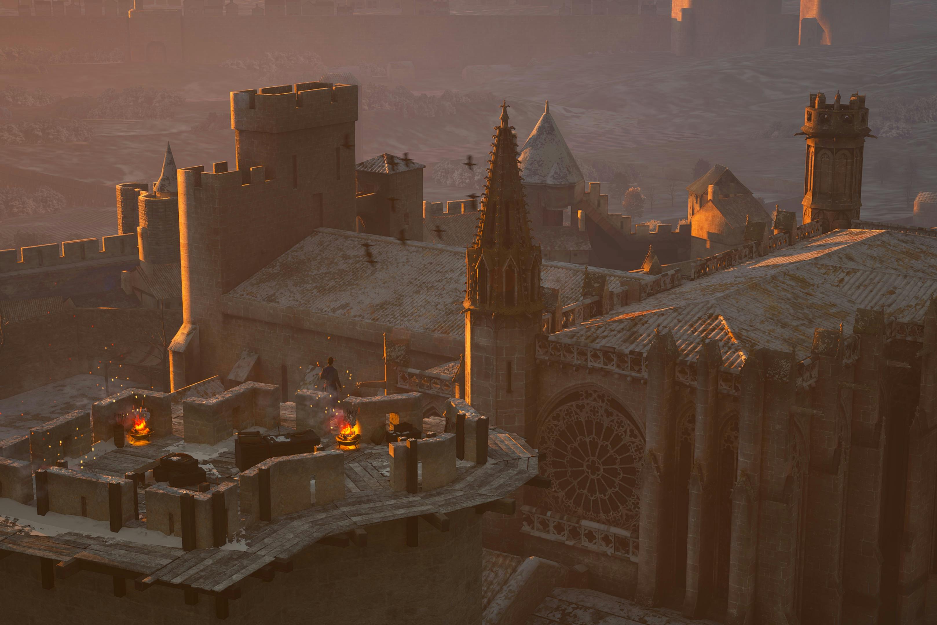 Średniowieczne dachy zamku o zachodzie słońca z grupą ludzi wokół małego ogniska. Widoczna jest gotycka architektura i iglice.