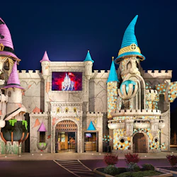 A whimsical castle-themed building with colorful turrets, featuring a sign reading "Castle of Chaos" on its facade.