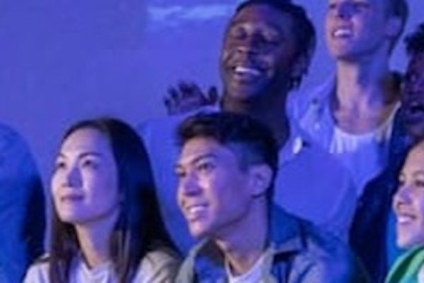 立って大きな水族館を観察したり、薄暗い環境で青い照明でディスプレイを見たりする人々のグループ。