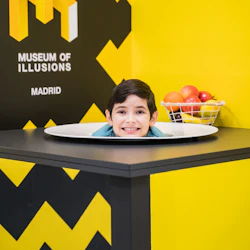 Ett barns huvud visas på ett fat på Museum of Illusions i Madrid. En korg med frukt placeras i närheten.