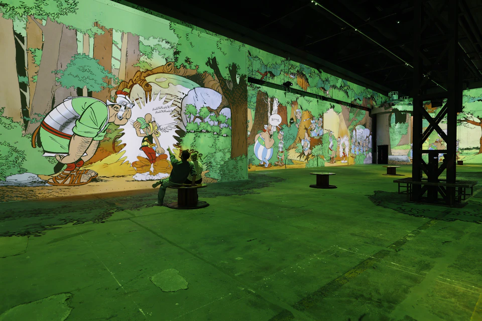 A large indoor space with walls covered in colourful cartoon-style artwork and seating areas dotted around the floor.