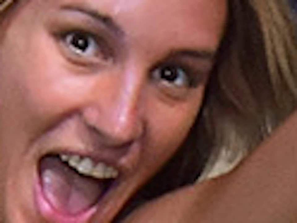 Woman in a yellow top and denim shorts jumps inside a mirrored, kaleidoscopic room.