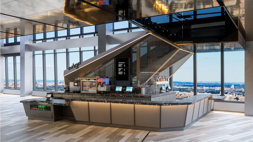 A modern cafe counter with beverage dispensers, menu screens, and a geometric backdrop, located in a high-rise setting.