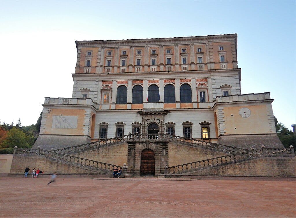 中心是一栋大型多层历史建筑，楼梯对称。 很少有人坐在前台行走。