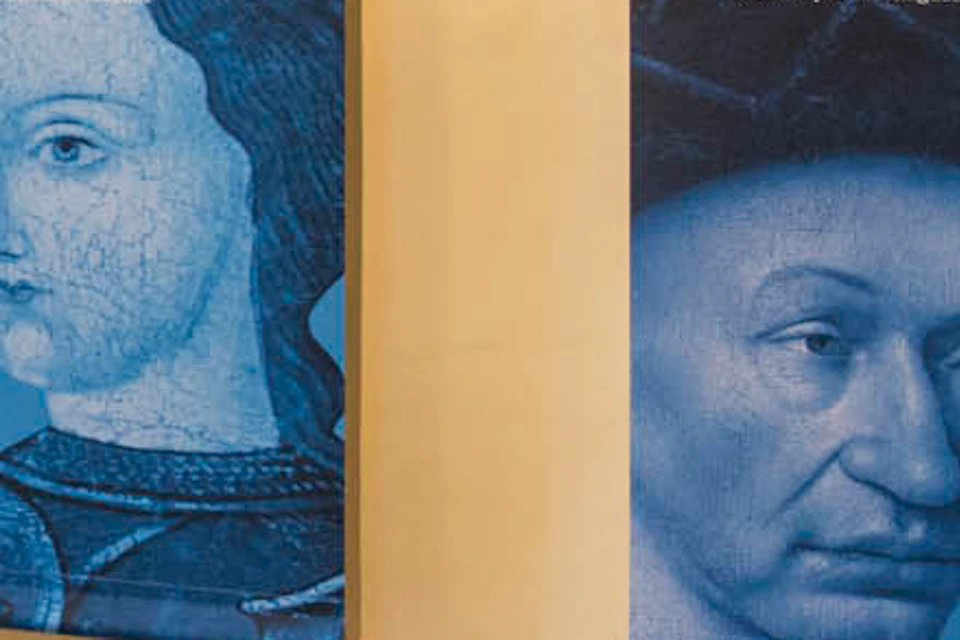 A museum exhibit featuring banners of Jeanne d'Arc and Charles VII, with a 3D table display and a visitor walking past.