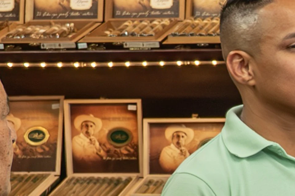 This image captures the fascinating process of crafting authentic Cuban cigars at a local cigar factory in Little Havana