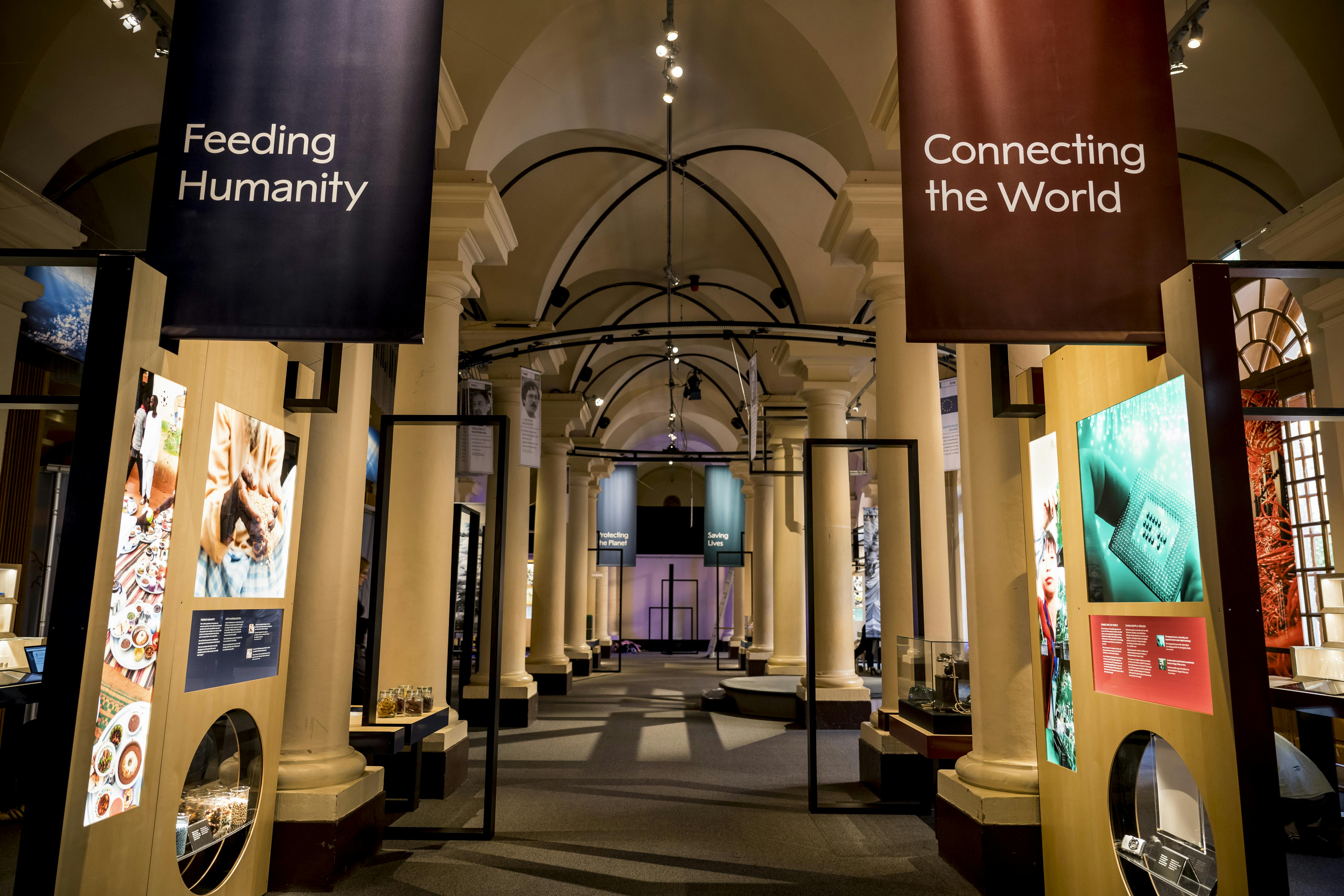 Corridoio ad arco con striscioni informativi, "Nutrire l'umanità" e "Connettere il mondo", esposti su entrambi i lati.