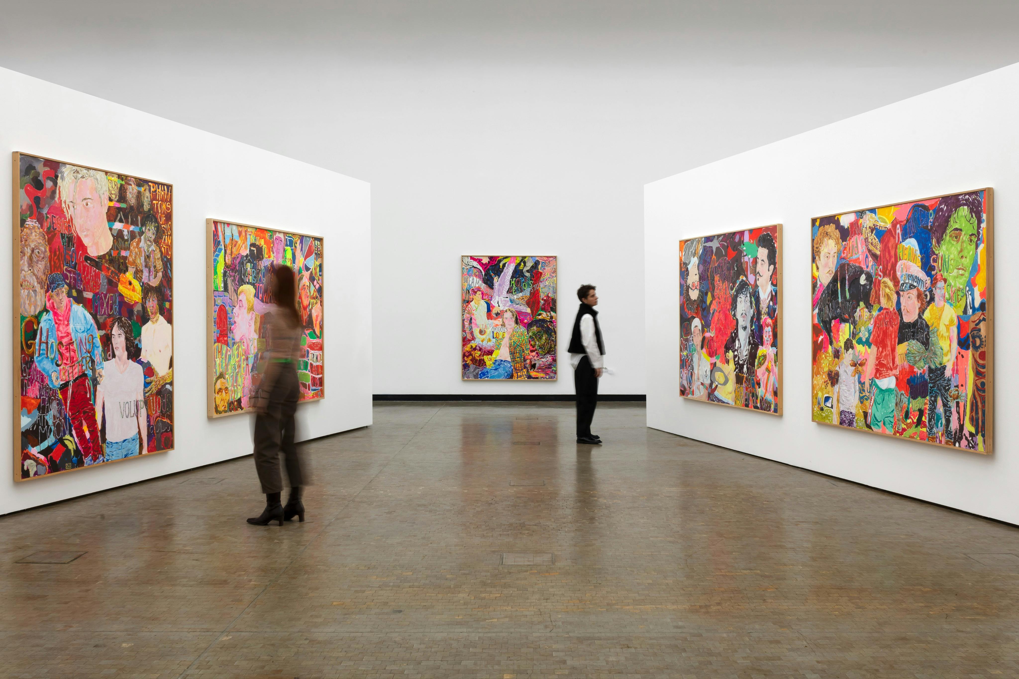 Et gallerirum med farverige malerier udstillet på hvide vægge og to personer, der observerer kunsten.