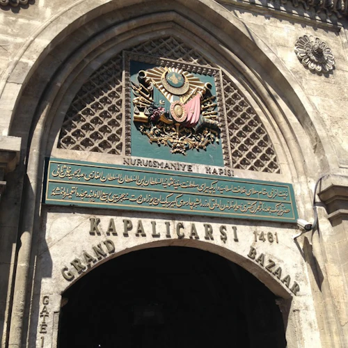 Archway-entré till Grand Bazaar i Istanbul, med intrikata sniderier, ett krön och arabisk skrift. På skylten står det "Kapalıçarşı 1461."